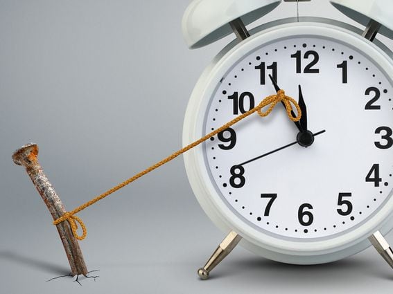 Time on clock stop by nail delay concept. (Dimj/Shutterstock)