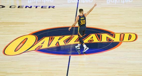 Stephen Curry of the Golden State Warriors stands on the Oakland logo at center court of the Chase Center in San Francisco, Calif.