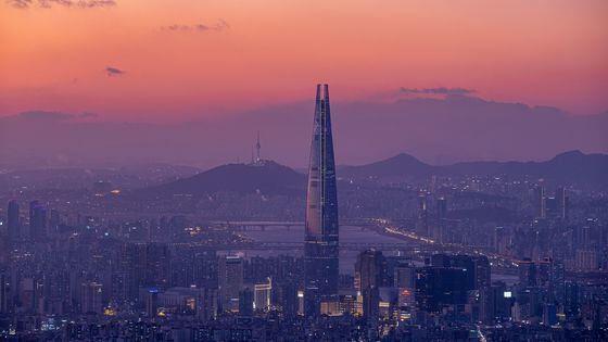 Seoul at dusk with Lotte Tower and mountains in background
