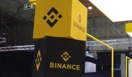 Two large stacked blocks displaying Binance's logo at a trade show.
