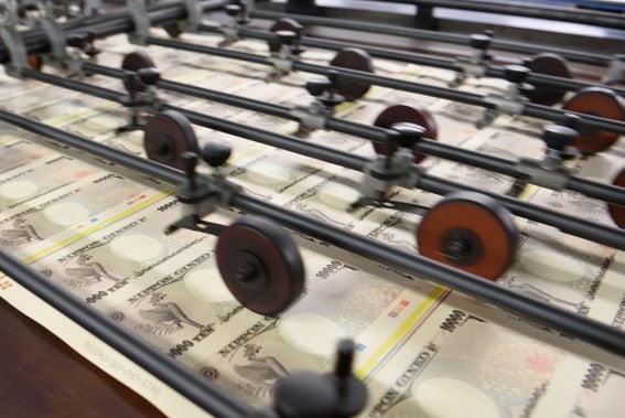 Sheets of Japanese 10,000 yen banknotes move through a machine at the National Printing Bureau Tokyo. 