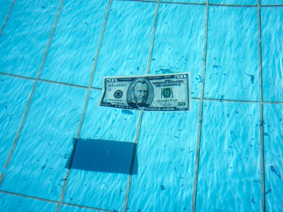 CDCROP: Fifty dollar bill swimming on clear blue water (Getty Images)