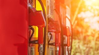 Colorful gas pump filling nozzles in warm sunset, representing Ethereum gas fee market.