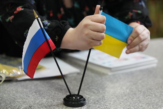 SANDY, UT - MARCH 04: A worker displays a Russian and Ukrainian flag at Colonial Flag on March 4, 2022 in Sandy, Utah. Colonial Flag has been overwhelmed with orders for the Ukrainian flag since Russia's invasion of Ukraine on February 24, 2022. (Photo by George Frey/Getty Images)