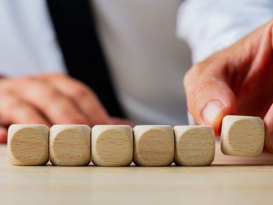 CDCROP: Businessman placing six blank wooden dices in a row (Gajus/iStock/Getty Images Plus)
