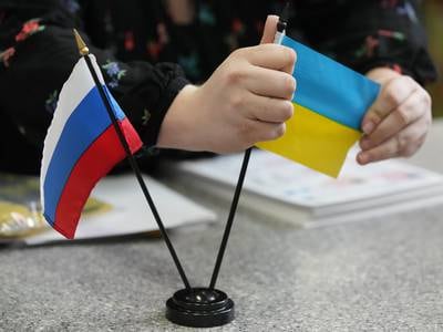 SANDY, UT - MARCH 04: A worker displays a Russian and Ukrainian flag at Colonial Flag on March 4, 2022 in Sandy, Utah. Colonial Flag has been overwhelmed with orders for the Ukrainian flag since Russia's invasion of Ukraine on February 24, 2022. (Photo by George Frey/Getty Images)