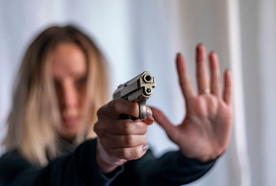 Young blonde girl with small pistol for self defense