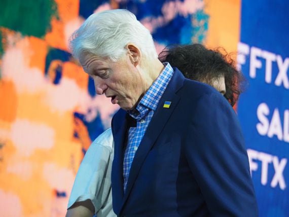 Sam Bankman-Fried standing behind former U.S. President Bill Clinton. (Danny Nelson/CoinDesk)