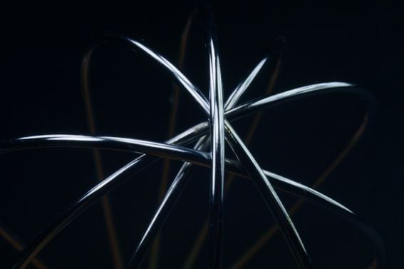 Close-up detail of a wire whisk against a black background, representing sharding, Danksharding on Ethereum.