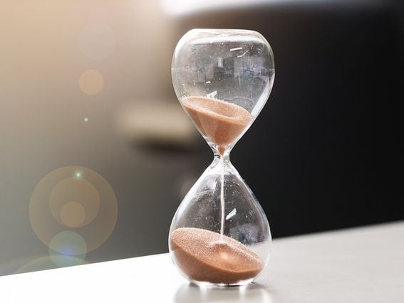 CDCROP: Hourglass on table office with copy space, Sand flowing through the bulb of Sandglass measuring the passing time. countdown, deadline, Life time and Retirement concept (Getty Images)