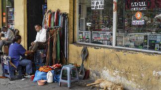 A shoe shiner works outside a shop that accepts bitcoin for payment in San Salvador, El Salvador. (Camilo Freedman/APHOTOGRAFIA/Getty Images)