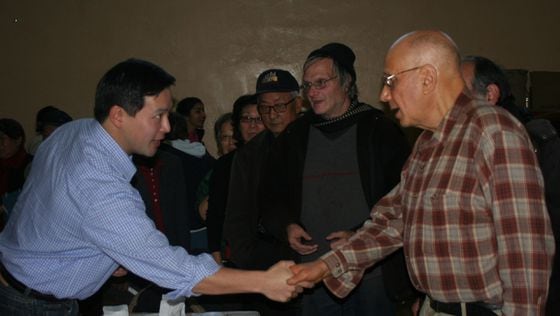 Assemblyperson Ron Kim shaking hands with a constituent 