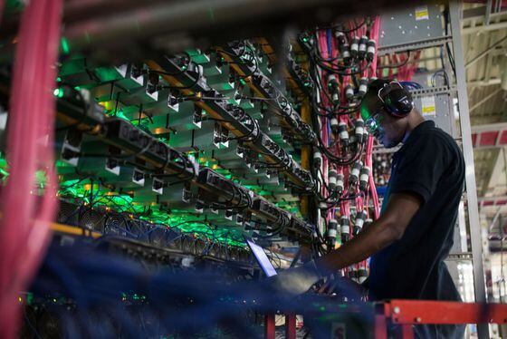A technician monitors cryptocurrency mining rigs at a Bitfarms facility in Saint-Hyacinthe, Quebec. (Getty Images)