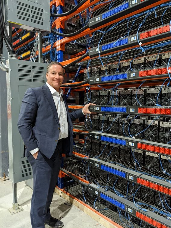 Bitfarms' president Geoff Morphy in front of rows of miners (CoinDesk)