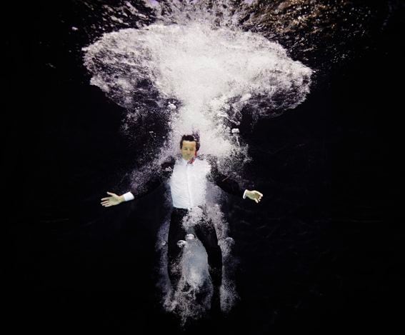 Businessman in suit plunging into water (Thomas M. Barwick/Getty Images)