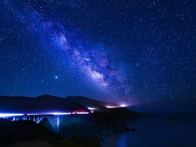 A distant bridge under a starry sky