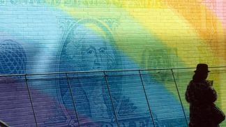 View of an unspecified wall decorated with an oversized, rainbow-colored dollar bill in Manhattan's Lower East Side neighborhood, New York, New York, February 1988. (Photo by Susan Wood/Getty Images)