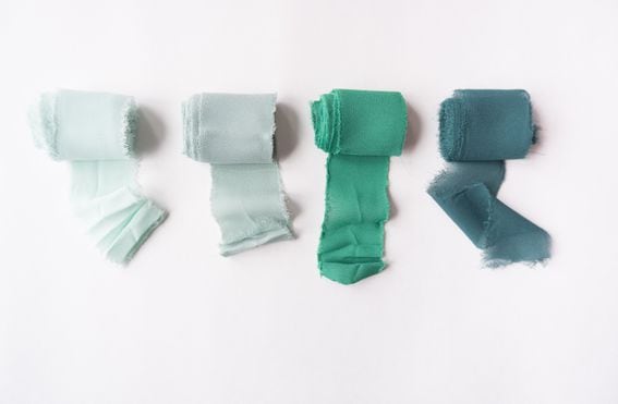 Four rolls of fabric in different shades of green, representing different kinds of Ethereum rollups.