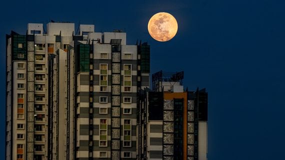 The moon rises over Chennai, India.