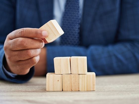 Shot of an unrecognisable businessman working with wooden building blocks in a modern office (iStockphoto/Getty Images)