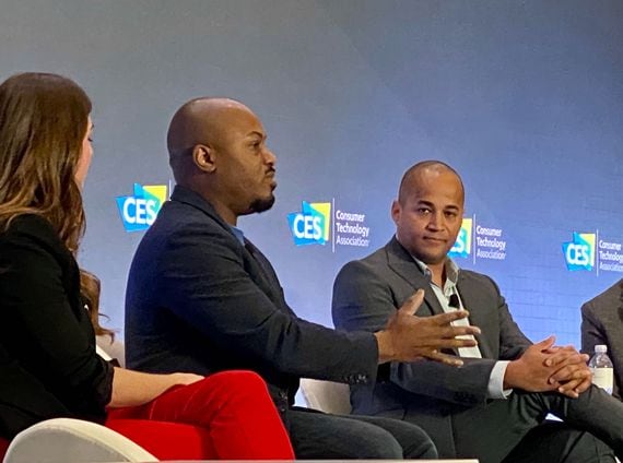 Decred's Akin Sawyerr (center) speaks on a CES panel with Libra Association Vice Chair Dante Disparte (right), photo by Brady Dale for CoinDesk