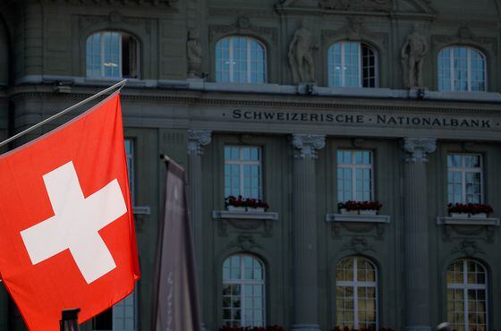 Swiss national flag in front of the Swiss National Bank (SNB) in Bern, Switzerland, on Thursday, June 17, 2021.