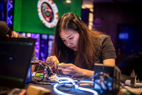 A woman works at an exhibit where attendees could make wearable NFTs during ETHDenver in Denver, Colorado, U.S., on Saturday, Feb. 19, 2022. ETHDenver is the largest Web3 #BUIDLathon in the world for Ethereum and other blockchain protocol enthusiasts, designers and developers.