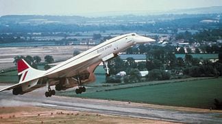 A supersonic Concorde jetliner takes off from the runway of an unidentified airport.