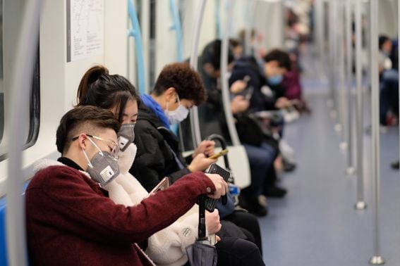 People wear surgical masks sitting in Shanghai subway due to the coronavirus outbreak. Image via Shutterstock