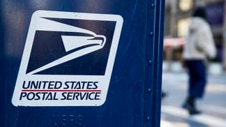 A USPS logo is seen on a mailbox in New York City.
