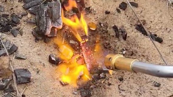Screen grab from video purporting to show a user smashing a hardware wallet with a hammer and then setting it ablaze with a blowtorch. (@oklahodl1/Twitter)
