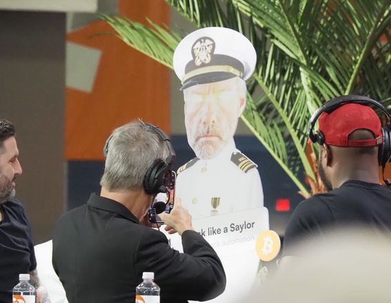 MicroStrategy CEO Michael Saylor snaps a photo of a cardboard cutout of himself at Bitcoin Miami 2022.