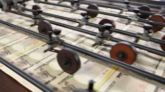 Sheets of Japanese 10,000 yen banknotes move through a machine at the National Printing Bureau Tokyo. 