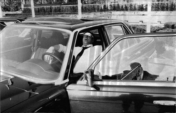A chauffeur takes a short nap while waiting for his passenger.