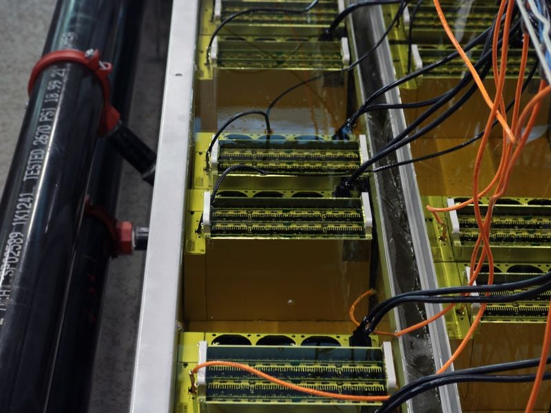 CleanSpark is experimenting with how many bitcoin mining machines it can put in a single immersion-cooled tank while overclocking them, meaning running them more intensely than the manufacturer's suggestion. (Eliza Gkritsi/CoinDesk)