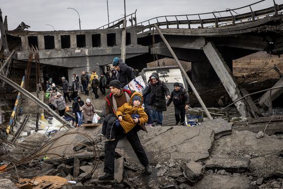 Residents of Irpin flee heavy fighting via a destroyed bridge as Russian forces entered the city on March 7, 2022.