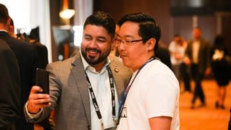 Litecoin founder Charlie Lee, right, poses with a fan