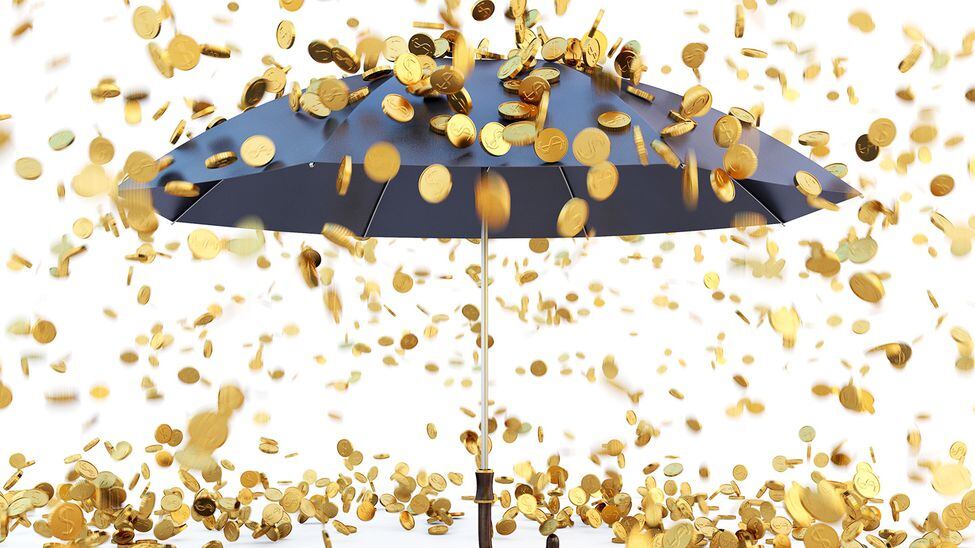 Monedas lloviendo sobre un paraguas (Getty Images)