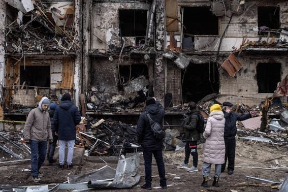 People look at the exterior of a damaged residential block hit by an early morning missile strike on February 25, 2022 in Kyiv, Ukraine.  (Chris McGrath/Getty Images)