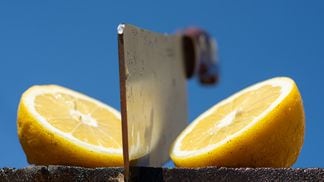 a cleaver chops a lemon in half