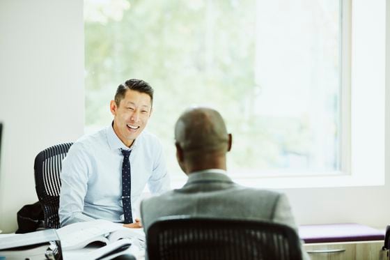 Smiling businessman in discussion with client in office
