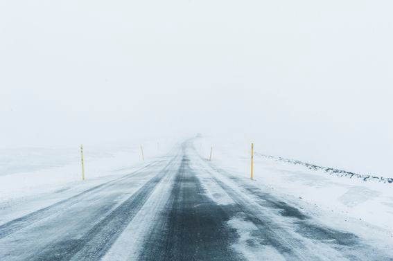 Mountain icy road during snowfall