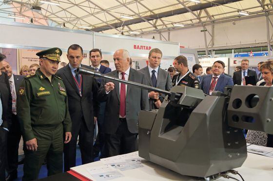 Rostec's CEO Sergey Chemesov shows a model of a tank to Russia's Minister of Defence Sergey Shoygu