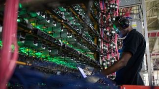 A technician monitors cryptocurrency mining rigs at a Bitfarms facility in Saint-Hyacinthe, Quebec.