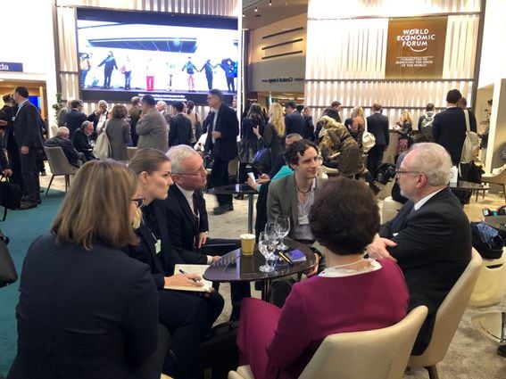 Blockchain thinker Glen Weyl (center, gray blazer) speaks with other attendees of the World Economic Forum Annual Meeting. (Photo by Leigh Cuen for CoinDesk)