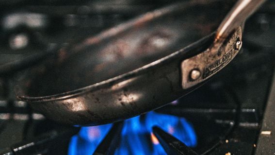 Frying pan over a burner on a stove (Andrew Valdivia/Unsplash)