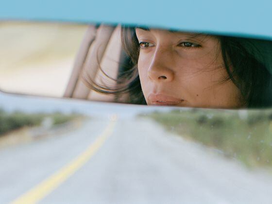 CDCROP: Woman driving car reflected in rear view mirror, close-up (Justin Pumfrey/Getty Images)
