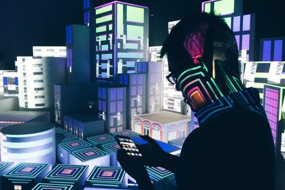 Man in silhouette looks at his mobile against a stylized digital cityscape.