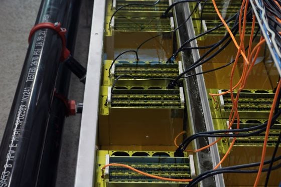CleanSpark is experimenting with how many bitcoin mining machines it can put in a single immersion-cooled tank while overclocking them, meaning running them more intensely than the manufacturer's suggestion. (Eliza Gkritsi/CoinDesk)