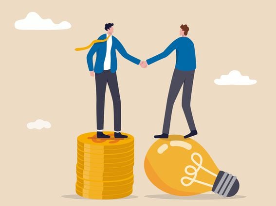 Idea pitching, fund raising and venture capital, selling business or merger agreement concept, entrepreneur businessman standing on lightbulb idea lamp shaking hands with VC on money coins stack.